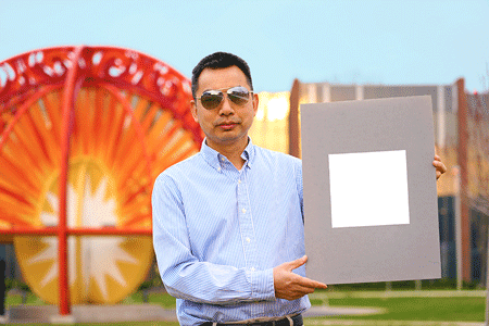 Xiulin Ruan, a Purdue University professor of mechanical engineering, holds up his lab’s sample of the whitest paint on record