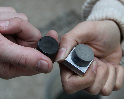 two hands holding conductive cement samples