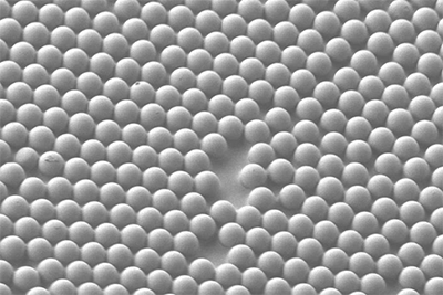 A scanning electron microscope image shows a microscale concave interface structure