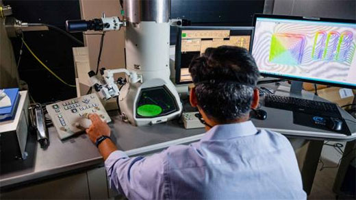 scientist views a magnified image from a Lorentz transmission electron microscope
