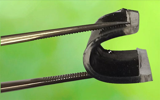 Tongs bending a flexible supercapacitor into a U shape