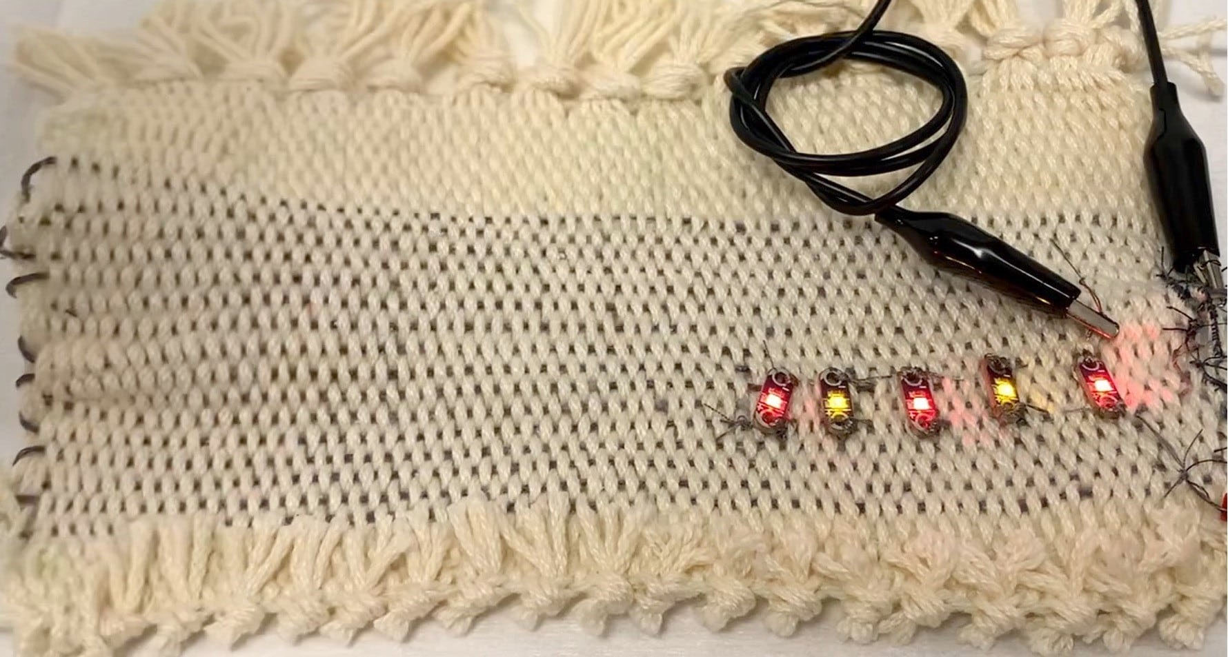 Supercapacitor yarns integrated in a fabric for powering LEDs