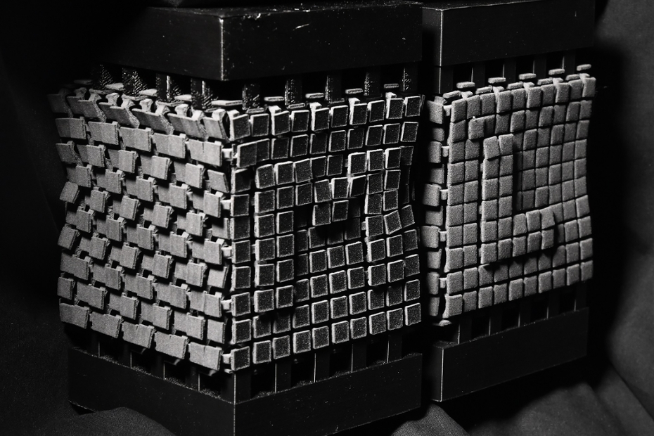 Two combinatorial mechanical metamaterials designed in such a way that the letters M and L bulge out in the front when being squeezed between two plates