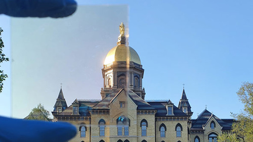 Notre Dame’s Golden Dome partially photographed through a sample (top left) of the TRC coating