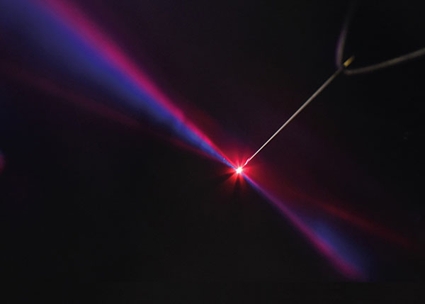 A strong laser pulse (red in the photo) is superimposed with a pulse of double the light frequency (blue)