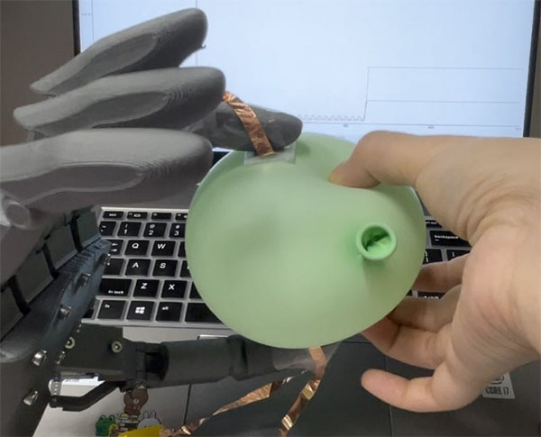 Testing an iontronic sensor's ability of tactile sensing via a robotic hand and a balloon