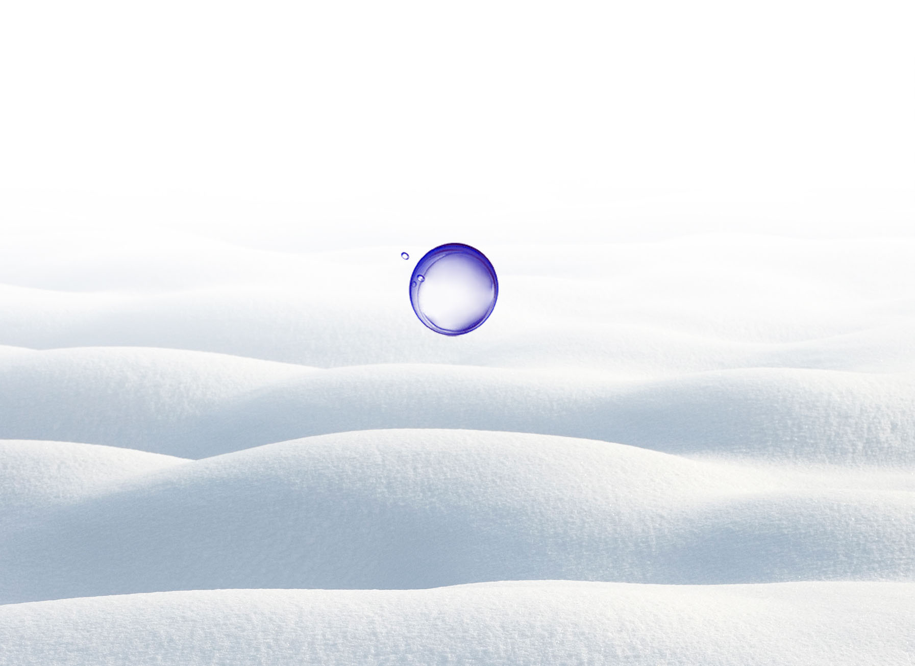 La imagen muestra una representación de la simetría resultante y muestra una gota de agua perfectamente simétrica emergiendo de una capa de nieve.