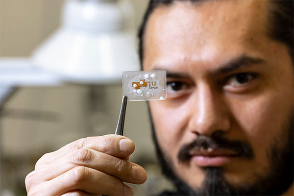 Gabriel Hernández Rodríguez holding a wafer-thin ice-repellant coating