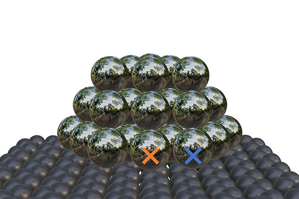 A tiny nanoparticle of silver (reflective atoms on top) on a carbon carrier. The boundary area (coloured markings) is where the activity is highest.