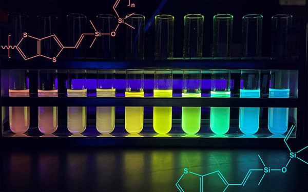 Test tubes containing the new silicone copolymers, separated by chain length, from long to short provide visual evidence of the varying band gap in the new semiconductor silicone