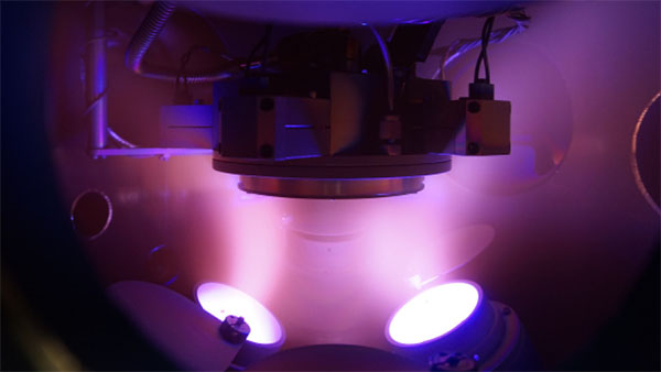 argon plasma in the vacuum chamber during magnetron sputtering, with the substrate in the center of the photograph