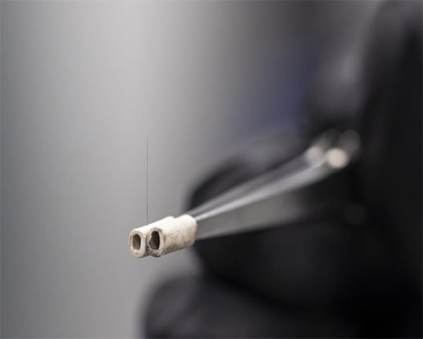 A carbon fiber is prepared for mounting in a device to test its adhesion to a polymer matrix