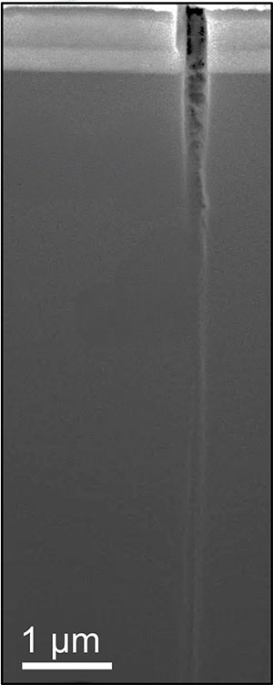 A microscope image shows how cracks that form in the ceramic top layer of a flexible electronic device can penetrate deep into the polymer substrate beneath