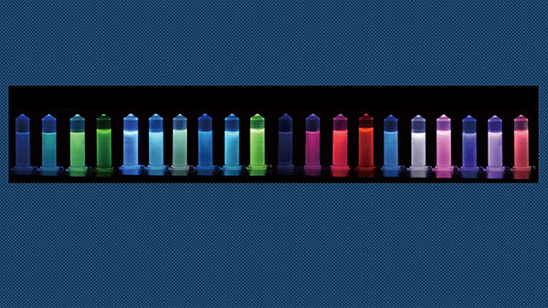 Photographed under 365-nm UV light, these vials display the distinctive luminescence of lanthanide-doped nanocrystals