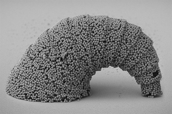 SEM image of a dangling croissant-shaped microstructure with a 3D curved surface assembled from SiO2 particles