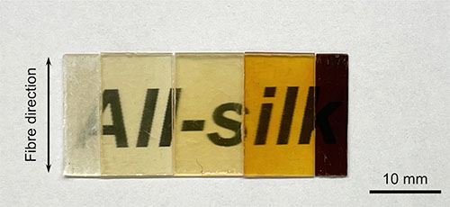 Five silk-derived materials are laid over text to demonstrate how the optical properties of the material change with the temperature and pressure at which the silk fibers are fused
