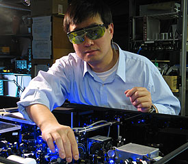 NIST physicist Jun Ye adjusts the laser setup for a strontium atomic clock in his laboratory at JILA