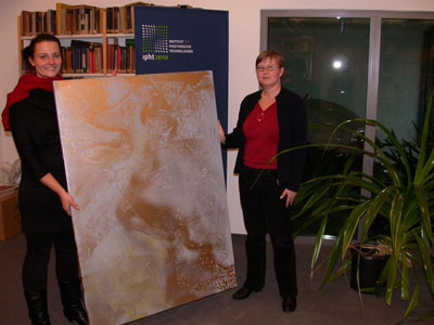 Katrin Sergejew (links) übergab im Dezember letzten Jahres das erste Bild der Reihe an Doktorandin Andrea Steinbrück aus der Abteilung Nanobiophotonik