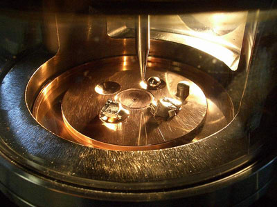Arc melter in which a plasma of up to 3000°C is produced between a tungsten tip (center) and a water-cooled copper plate