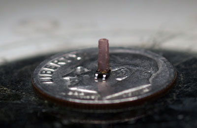 A magnetic crystal sits on the head of a dime for scale. Scientists exploit the randomness of the magnetic field in the crystal at the molecular level to control the properties of the magnet as a whole. The chip underneath the crystal is a magnetic sensor. 