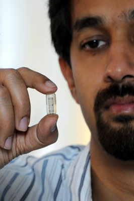 Rizwan Bashirullah, a University of Florida assistant professor of electrical and computer engineering, holds a pill capsule designed to signal when a patient has swallowed it