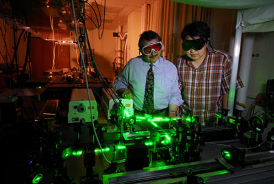 Mostafa El-Sayed (left) and Wei Qian shine laser light on cells with gold attached, allowing selective destruction of cancer cells