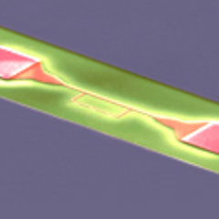 Impression of the interaction between a superconducting electrical circuit and a microwave photon – Electron microscopical picture of the superconducting circuit (red: Aluminum-Qubit, grey: Niob-Resonator, green: Silicon substrate) 