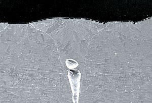 Cross-sectional scanning electron microscopy image of a microcavity formed in a block of stainless stell by laser engraving