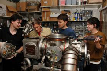 Graduate student Vincent Lonij (left), associate professor of physics Alex Cronin, research assistant Will Holmgren and undergraduate student Catherine Klauss perform maintenance on a chamber used to beam atoms through a grating to measure a tiny force that helps physicists better understand the structure of atoms.