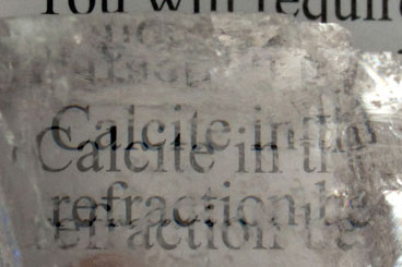 This image shows a calcite crystal laid upon a paper, causing all the letters to show double refraction