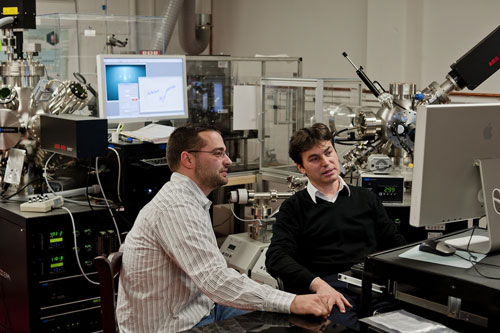 Doctoral student Benjamin Gray, left, and Jak Chakhalian in the laboratory with a unique state-of-the-art piece of equipment built last summer to fabricate atomic layers of complex oxides.