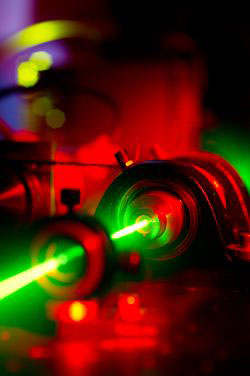 a green laser is shown as it leaves the ruby crystal