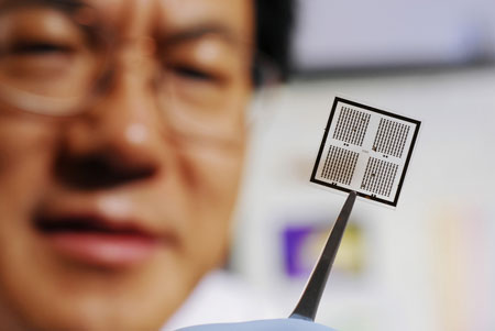 Regents professor Zhong Lin Wang holds an array of piezoelectrically modulated resistive memory (PRM) cells on which metal electrodes have been patterned using lithography