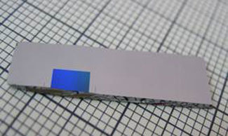 a silicon chip containing a square area where millions of deep nanopores were etched in a specified rectangular structure