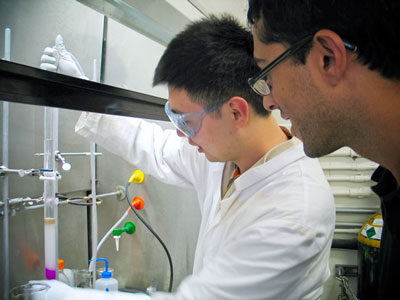 Neal Devaraj watches as undergraduate student Weilong Li works on a next step in their quest to create an entirely artificial cell.