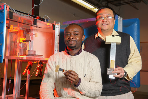 Felix Ewere, left, and Dr. Gang Wang near a wind tunnel they use for testing