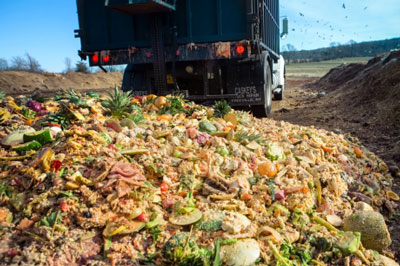 A truck dumps food waste at a composting facility