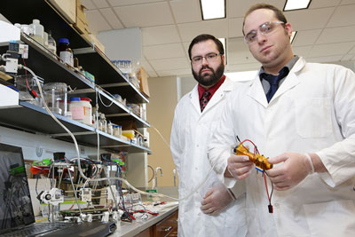 Devon Bane, left, and Tanner Carden with their CarmAl extruder in a lab at UAH’s Shelby Center for Technology