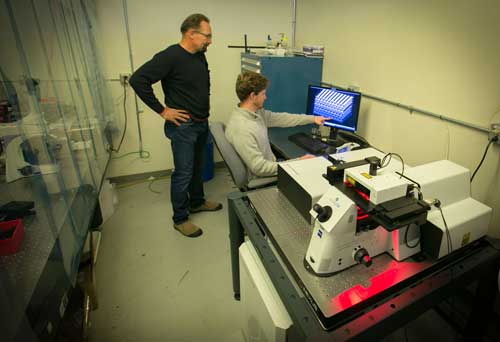 James Oakdale (seated) and Juergen Biener examine a 3D printed foam reservoir target
