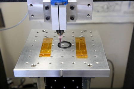 A carbon fiber composite ink extrudes from a customized direct ink writing 3D printer