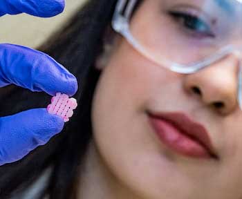 Rice research scientist Maryam Elizondo holds a 3D-printed scaffold engraved with grooves for the deposition of live cells for implantation