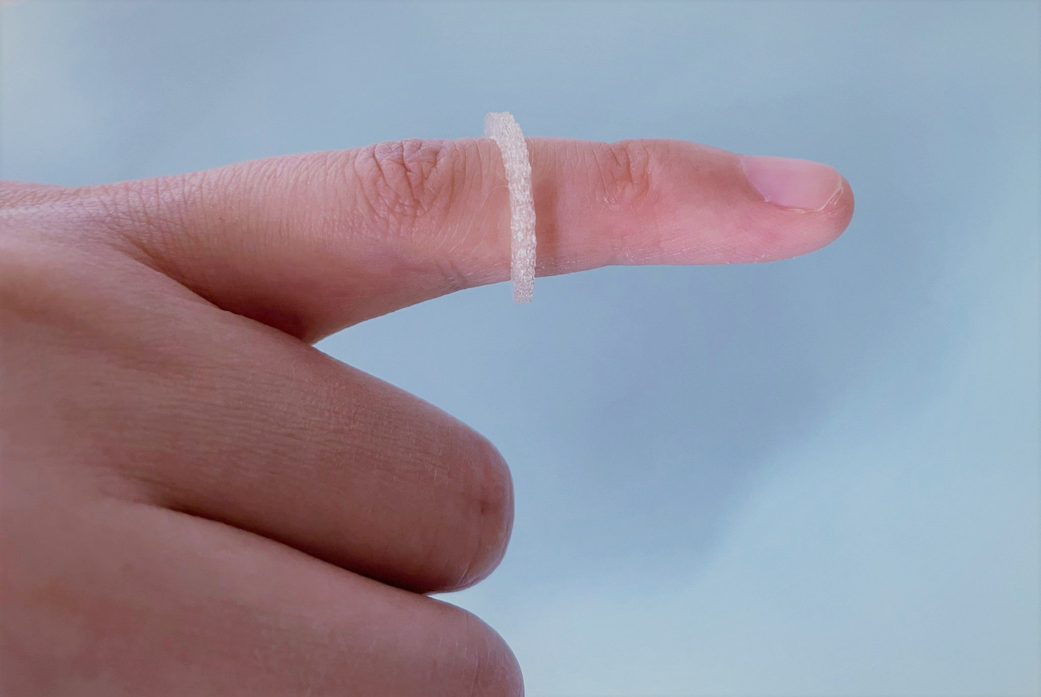 3D printed insect-repellent ring on a finger