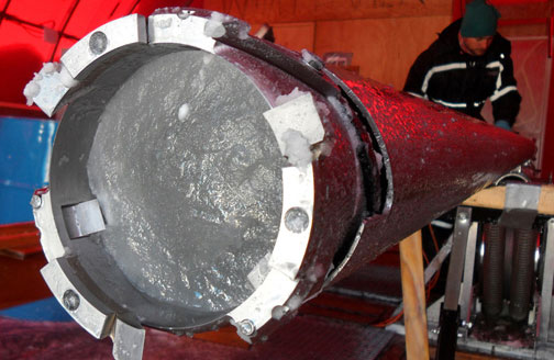 A core section of Greenland ice is prepared for removal from the barrel of the core drill
