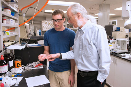 Dan Buttry, professor and chair of ASU's Department of Chemistry and Biochemistry, examines a battery sample with graduate student Tylan Watkins