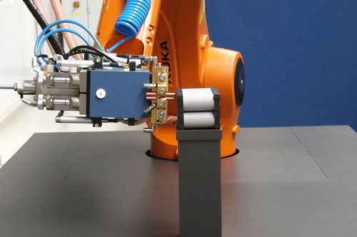 A robot welds cells to form modules that are then connected to an energy storage system