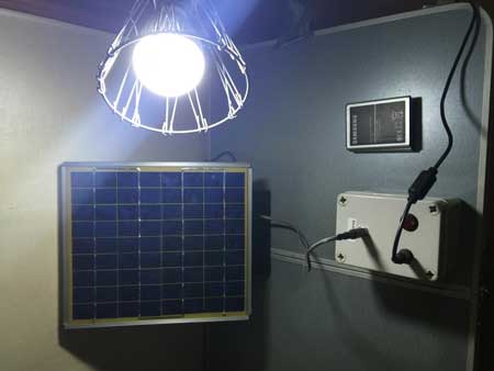 prototype system consisting of a solar panel and 12V LED lamp wired to a battery pack containing three Samsung Galaxy Note 2 batteries