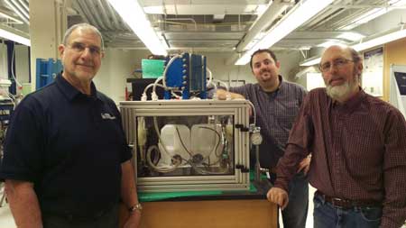 left-to-right, researchers Bob Savinell, Nick Sinclair and Jesse Wainright, with a 100-watt version of their iron-flow battery