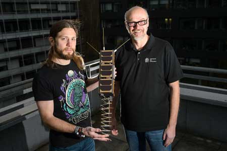 Gilles Nies and Professor Holger Hermanns with the replica of a nano satellite