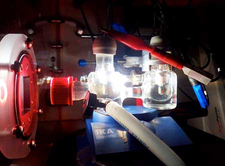 Experimental two-electrode setup showing the photoelectrochemical cell illuminated with simulated solar light