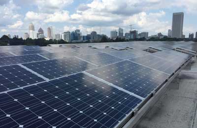 Rows of photovoltaic panels are shown atop a building